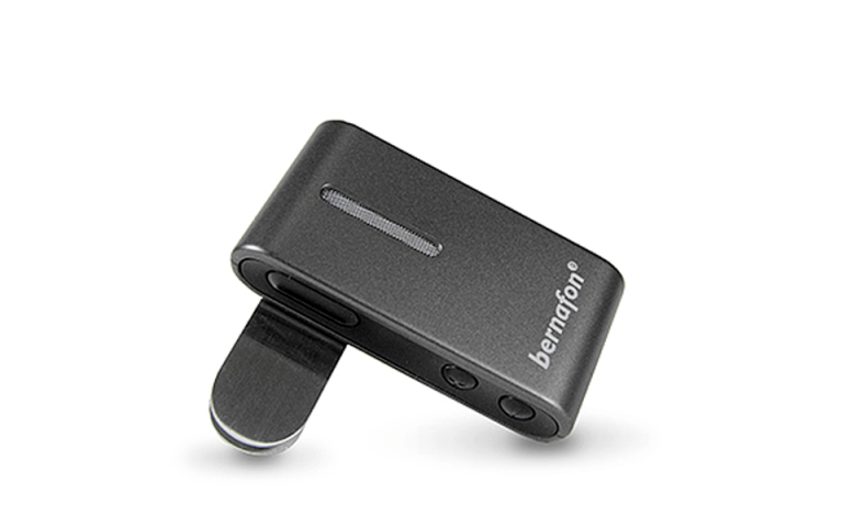 The Bernafon SoundClip-A is a compact, rectangular black device with a clip and two side buttons, branded with "bernafon," designed for assistive hearing technology.